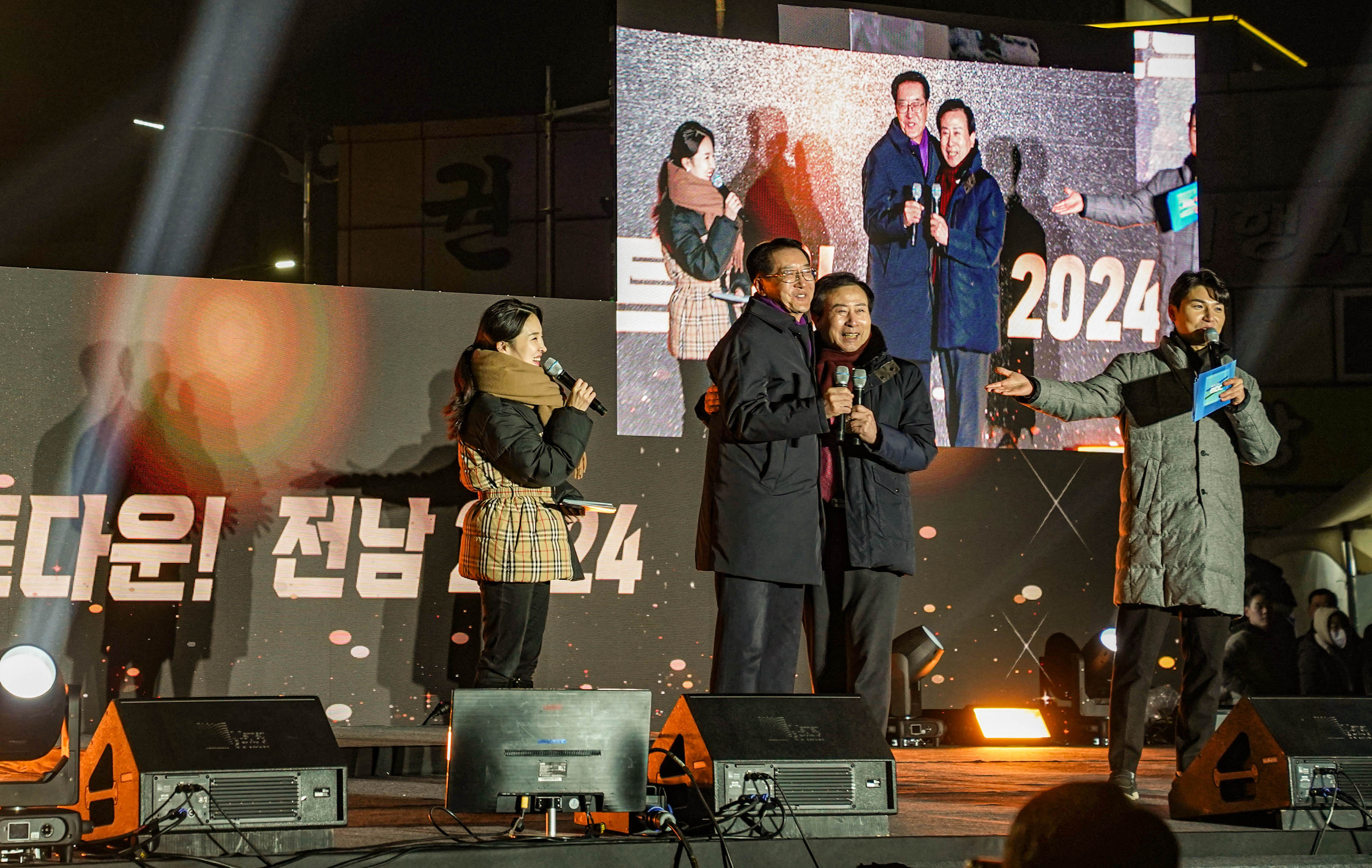 무대위에서 관계자와 목포시장 박홍률이 가벼운 포옹을 하는 모습