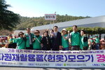'기후 위기 극복! 2050 탄소중립 실현을 향한 시민실천운동 자원재활용품(헌옷) 모으기 경진대회' 현수막 뒤에서 '용당1동' 표지판을 들고 기념 촬영을 하는 사람들.