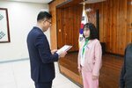 4월 정례조회에 정장을 입고 안경을 낀 남성이 위아래 분홍색 자켓과 바지를 입은 김숙자에게 패를 수여하고 있다